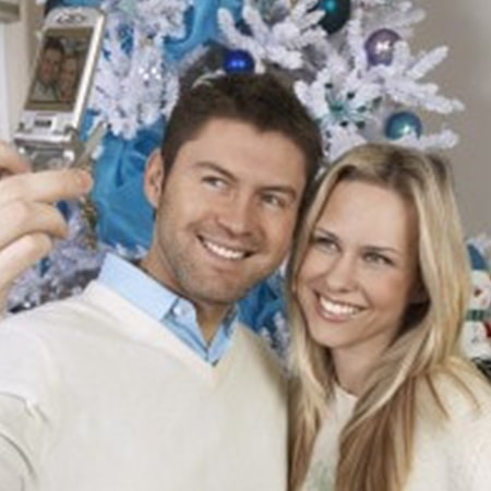 Couple taking a selfie in front of a holiday tree